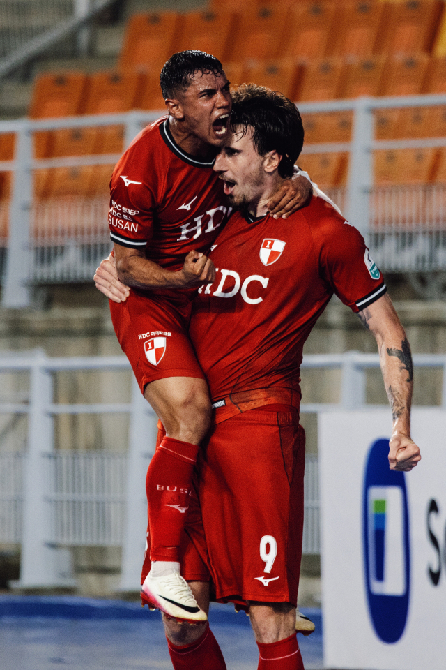 부산 아이파크의 201cm 장신 공격수 곤잘로(오른쪽)가 지난달 29일 수원 삼성과의 18라운드 경기에서 후반 종료 직전 극적인 동점골을 넣고 동료 선수와 기뻐하고 있다. 부산 아이파크 제공