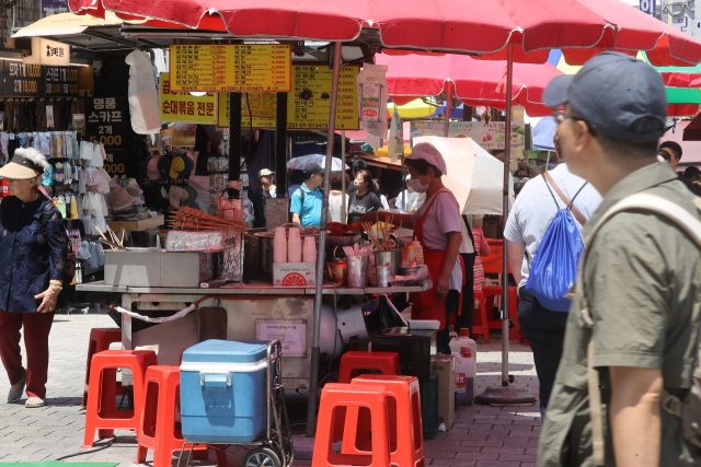 지난달 22일 서울 남대문시장에서 시민들과 관광객들이 상점을 둘러보고 있다. 연합뉴스