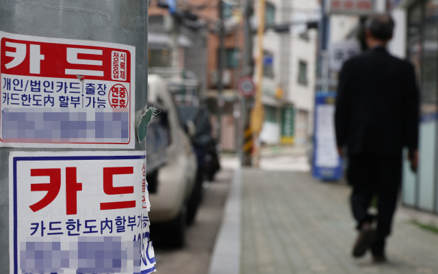 정부의 ‘가계부채 관리 방안’에 따라 전 금융권에서 받을 수 있는 신용대출 한도가 연 소득 100% 이내로 제한된 가운데 금융당국이 카드사의 카드론도 신용대출로 분류하기로 했다. 시내에 붙은 카드 대출 광고. 연합뉴스