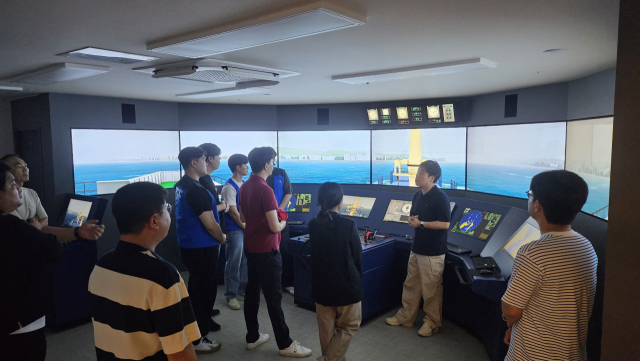 부산 중구 중앙동 팬오션 2층에 자리한 포스에스엠 HR트레이닝센터 선박 모의 조종실에서 교육생들이 강사(오른쪽 두 번째)의 설명을 듣고 있다.