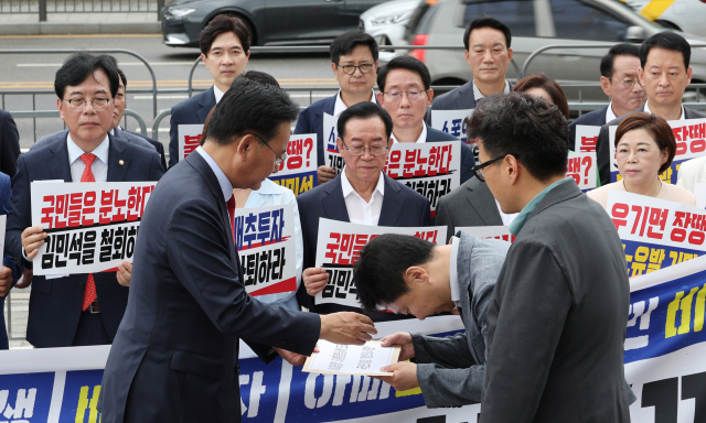 국민의힘 유상범 의원이 1일 서울 용산 대통령실 앞에서 현장 의원총회를 마친 뒤 이광수 대통령실 정무수석실 선임행정관과 오경환 행정관에게 김민석 국무총리 후보자 지명 철회를 요구하는 서한을 전달하고 있다. 연합뉴스
