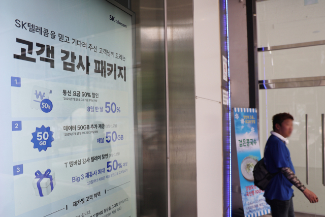 SK텔레콤이 지난 4월 발생한 해킹 사태 이후 통신사를 변경하는 가입자에 대한 위약금 면제를 결정한 가운데 지난 6일 서울 시내의 한 SK텔레콤 대리점에 ‘고객 감사 패키지’ 안내문이 띄워져 있다. 연합뉴스