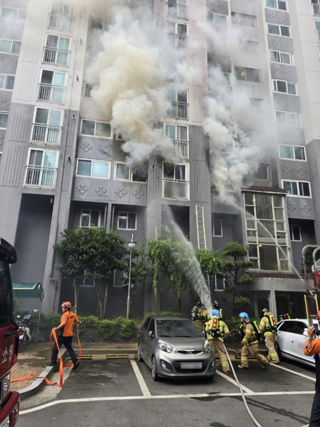 지난 13일 낮 12시 20분께 부산 북구의 한 아파트에서 불이 나 소방대원이 화재를 진압하고 있다. 이 화재로 80대 노모와 50대 큰아들이 숨졌다.부산경찰청 제공