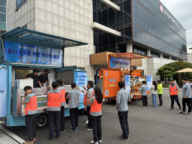 한국동서발전 울산발전본부 직원들이 푸드트럭에서 나눠주는 컵빙수 등 온열질환 예방 디저트를 먹기위해 기다리고 있다. 동서발전 제공