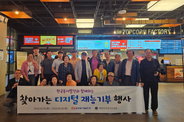 상이군경 어르신들과 한국동서발전 직원들이 키오스크 영화예매 체험 활동을 한 후 기념사진을 촬영하고 있다. 동서발전 제공