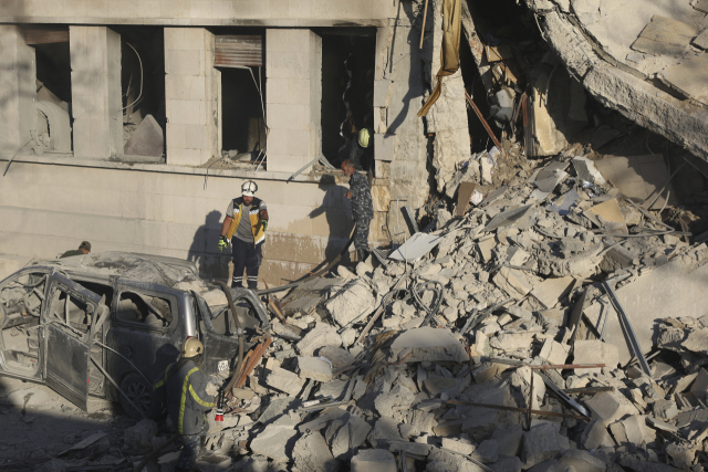 16일(현지 시간) 시리아 다마스쿠스에서 이스라엘의 공습을 받은 시리아 국방부 건물을 구조대원들이 살펴보고 있다. AP연합뉴스