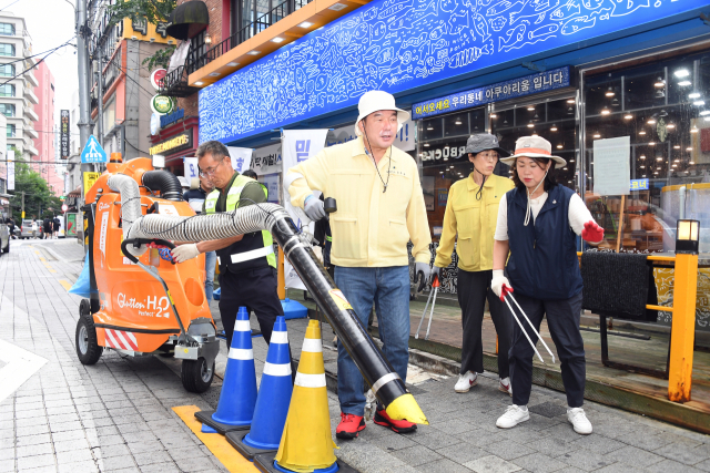 장준용 동래구청장이 16일 부산 동래구 명륜1번가 내 배수구, 빗물받이 등에 쌓인 담배꽁초 등을 새로 도입한 친환경 노면진공청소기로 제거하고 있다.