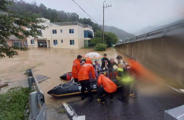 17일 집중호우가 쏟아진 경남 밀양시 무안면 한 노인요양원에서 밀양소방서 구조대원들이 환자와 직원들을 구조하고 있다. 연합뉴스