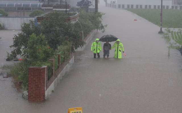 17일 오후 경남 창녕군 도천면 송진2구 마을에서 경찰이 주민을 대피시키고 있다. 창녕군은 이날 0시부터 오후 3시55분 기준 도천지점 강수량이 272㎜에 달하자 인근 마을회관으로 대피해달라고 재난 문자를 발송했다. 연합뉴스