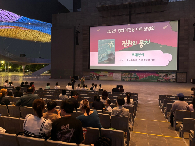 지난 16일 오후 부산 해운대구 영화의전당 야외극장에서 진행된 '길 위의 뭉치' 시사회에서 오성윤 감독과 명필름 이은 대표가 무대 인사를 하고 있다. 김희돈 기자