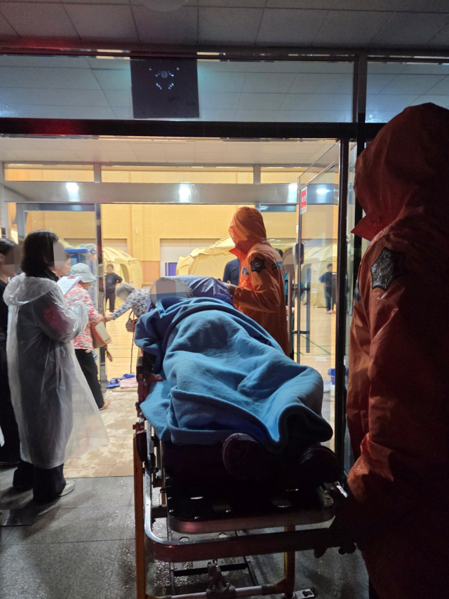 경남소방대원들이 지난 18일 밤 창녕군 계성면 계성천 수위 상승에 따라 인근 6개 마을 주민 64명이 대피를 돕고 있다. 경남소방본부 제공