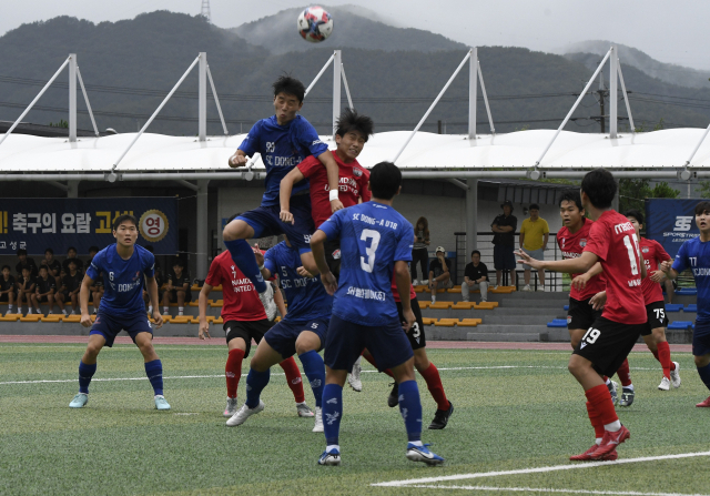 부산 SCDONGA와 인천 남동유나이티드 선수들이 지난 18일 경남 고성군 회화면체육공원에서 열린 제62회 청룡기 전국고교축구대회 조별리그 10조 경기에서 공 경합을 벌이고 있다. 부산시축구협회 제공