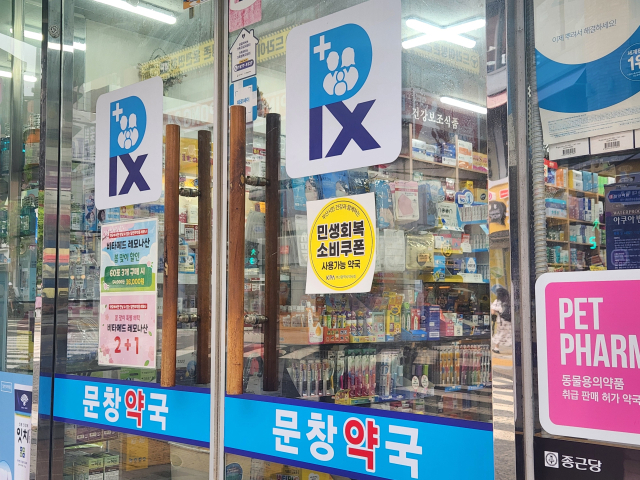 20일 부산의 한 약국에 ‘민생쿠폰 사용 가능’ 스티커가 붙어 있다. 김재량 기자 ryang@