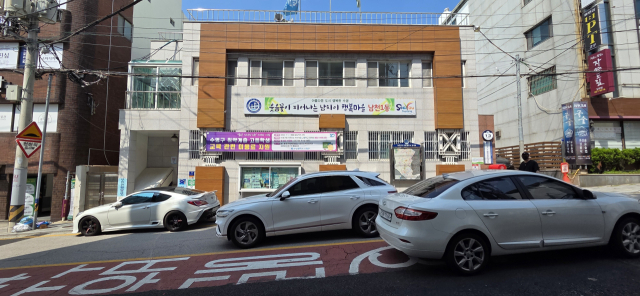 부산 수영구 남천1동행정복지센터 앞 도로 모습. 전용 주차장이 없어 주차된 차량을 피해 운전해야 한다. 박수빈 기자