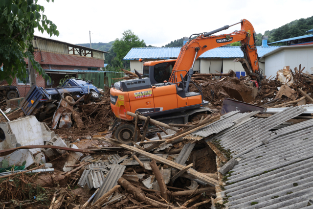 21일 경기도 가평군 조종면 신상리 산사태 현장에서 포클레인이 도로에 쌓인 토사물을 치우며 복구 작업을 벌이고 있다. 연합뉴스