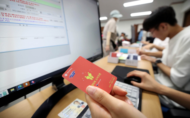 민생회복 소비쿠폰 지급 첫날인 지난 21일 광주 북구 두암3동 행정복지센터에서 한 직원이 현물카드를 준비하고 있다. 연합뉴스