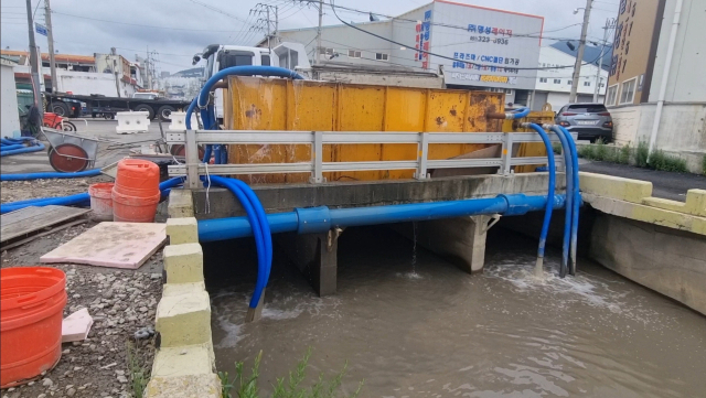 지난 16일 부산 사상구 감전2중천에 있는 침수조(노란색)와 도시철도 공사장에서 나온 파이프(파란색). 침수조에서 나오는 우측 파이프와 달리 좌측 파이프는 공사장에서 바로 하천으로 연결된 모습이다. 김준현 기자