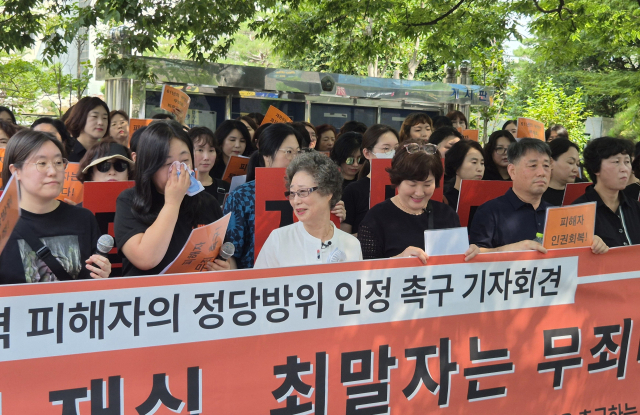23일 오전 부산지방법원 앞에서 열린 ‘성폭력 피해자의 정당방위 인정 촉구’ 기자회견에 참석한 최말자(가운데 흰색 옷) 씨. 이우영 기자 verdad@busan.com