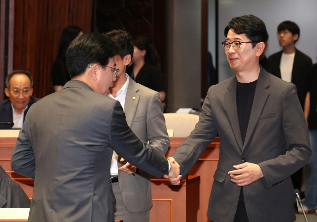 국민의힘 송언석 비상대책위원장 겸 원내대표(왼쪽)가 23일 서울 여의도 국회에서 열린 의원총회에서 주진우 의원과 악수하고 있다. 연합뉴스