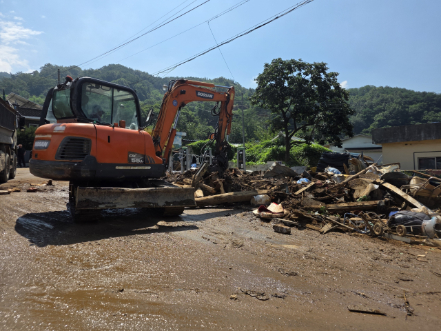24일 오전 경남 산청군 산청읍 병정마을 입구에 쌓인 토사와 가재도구 등을 굴착기가 정리하고 있다. 강대한 기자