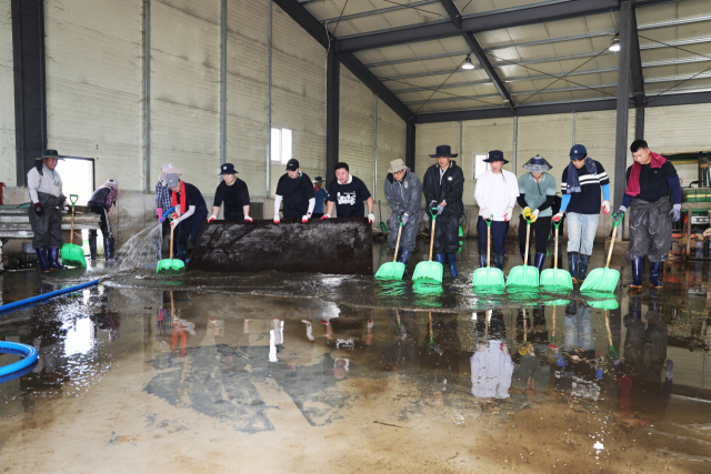 양산시 복구 지원단이 23일 침수 피해를 본 산청군 신안면의 한 농기계보관소를 청소하고 있다. 양산시 제공