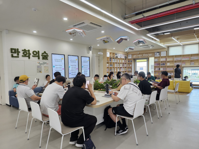 ‘만화의 숲’ 곳곳에서 열독하는 방문객들. 오전부터 만석이라 빈자리를 찾기가 쉽지 않다.
