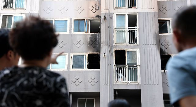 지난 14일 부산 북구의 한 아파트 화재 현장에서 주민들이 경찰과 소방 등 합동 감식을 지켜보고 있다. 정종회 기자 jjh@