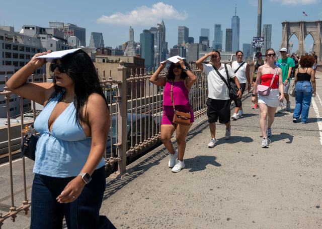 미국 뉴욕 브루클린의 체감 온도가 최소 38도가 넘을 것으로 예상되는 25일(현지 시간) 사람들이 브루클린 브리지를 건너고 있다. 미국 전역이 또 한 번 기록적인 폭염의 여름을 겪고 있는데, 미 동부 해안 대부분은 며칠째 계속되는 찜통더위에 시달리고 있다. AFP 연합뉴스
