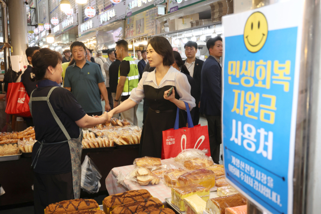 김혜경 여사가 25일 인천 계양산전통시장을 방문해 제과점에서 민생회복 소비쿠폰을 이용해 제품을 구매하며 상인과 인사하고 있다. 대통령실통신사진기자단