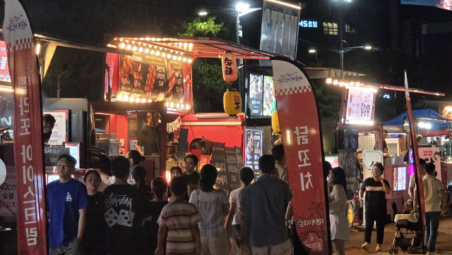 지난 25일 밤 9시께 부산 해운대구 해운대해수욕장 프로모션존 모습. 푸드트럭 앞이 음식을 구매하려는 방문객들로 붐비고 있다. 박수빈 기자 bysue@