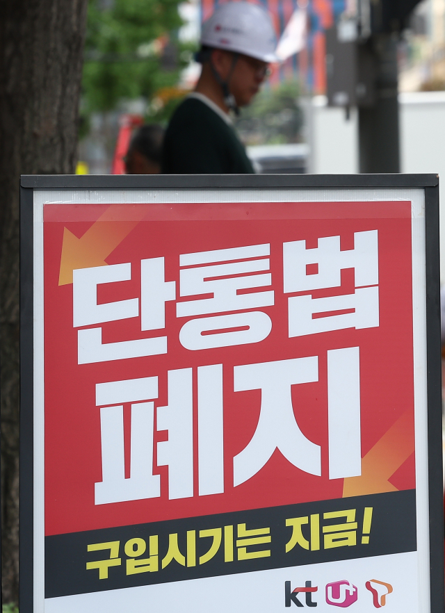 서울의 한 휴대폰 판매점 앞에 ‘단통법 폐지’라고 적힌 안내판이 놓여 있다. 연합뉴스