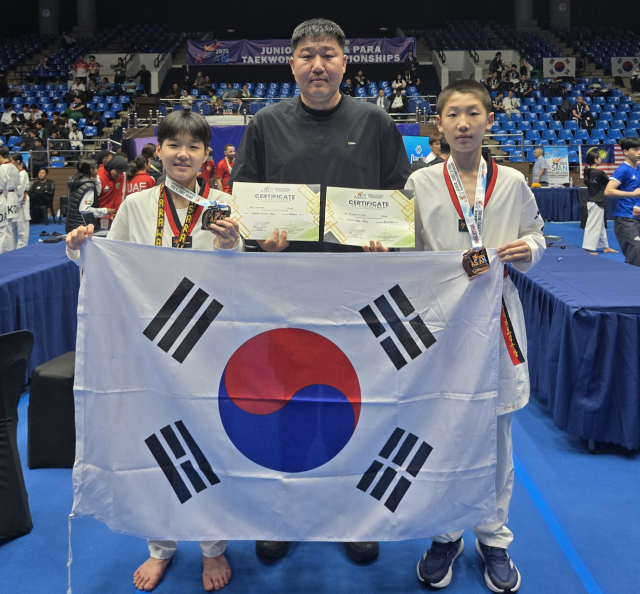 지난 27일 말레이시아 쿠칭에서 개막한 제6회 아시아태권도유소년선수권대회에 대한민국 국가대표로 출전한 고성 소가야중 서윤아(왼쪽) 양과 철성중 전용현(오른쪽) 군이 각각 -44kg급 은메달과 -45kg급 동메달을 목에 걸었다. 가운데는 두 선수를 지도한 고성군유소년태권도단 최창윤 감독이다. 고성군 제공