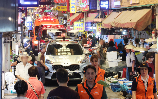 부산 부산진소방서와 부산진구청, 부전시장상인회 등이 30일 오전 부전시장에서 화재 발생을 대비해 소방차량과 주차단속차량 등을 동원, 소방통로 확보 훈련을 하고 있다. 정종회 기자 jjh@