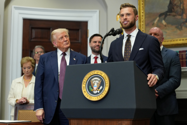 31일(연합뉴스) 미국 워싱턴 DC 백악관 루즈벨트룸에서 열린 행정명령 서명식에서 도널드 트럼프 미국 대통령(왼쪽)이 지켜보는 가운데 캔자스시티 치프스 키커 해리슨 버커가 연설하고 있다. EPA 연합뉴스