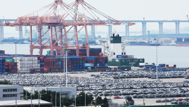 한국과 미국의 관세 협상이 타결된 지난 31일 경기도 평택항에 세워져 있는 수출용 자동차 뒤로 컨테이너가 쌓여 있다. 연합뉴스