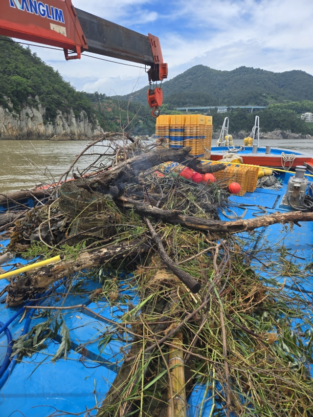 거제시 연안이 지난 집중호우 때 떠밀려 온 각종 해양 쓰레기로 몸살을 앓고 있다. 지역 어민들이 어선을 동원해 쓰레기를 수거하고 있다. 낙동강어업피해대책위원회 제공