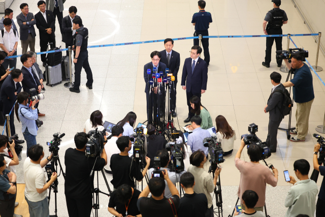 미국과의 무역협상을 마친 김정관 산업통상부장관이 1일 인천국제공항 제2여객터미널을 통해 귀국해 취재진 질문에 답하고 있다. 왼쪽부터 김정관 장관, 구윤철 경제부총리, 여한구 통상교섭본부장. 연합뉴스