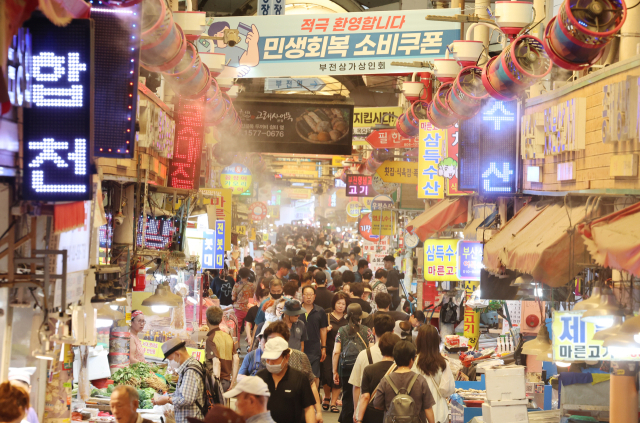 찜통 폭염이 이어지는 가운데 부산 부산진구 부전시장에 상인회에서 내건 '민생회복 소비쿠폰 환영' 펼침막과 쿨링 포그가 방문객들을 맞이하고 있다. 연합뉴스