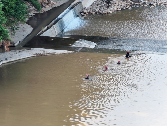 지난달 31일 소방대원들이 황톳빛으로 변한 산청군 하천에서 수색을 진행하고 있다. 경남소방본부 제공
