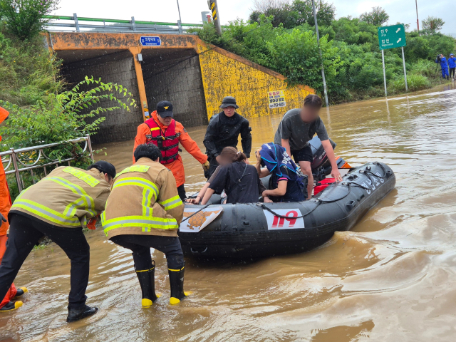 지난달 19일 오후 경남 의령군 대의면 집중호우로 인해 마을이 침수돼 출동한 소방대원들이 보트를 이용해 건물에 고립된 마을 주민을 구조하고 있다. 소방청 제공. 연합뉴스