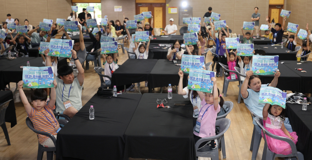 어린이들에게 독서의 재미를 전달하고 체험활동으로 창의력을 길러주기 위한 ‘2025 가족이 함께하는 독서 여름방학 캠프’가 9일 부산 금련산청소년수련원에서 열렸다. 개회식에서 참가 가족들이 책을 들고 기념촬영을 하고 있다. 이재찬 기자 chan@