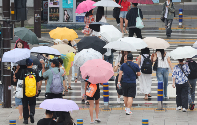 연일 이어진 비에 낮 최고기온이 30도 아래로 떨어진 10일 부산 동구 초량동 부산역 앞 횡단보도에 시민들이 우산을 받쳐들고 지나가고 있다. 정종회 기자 jjh@