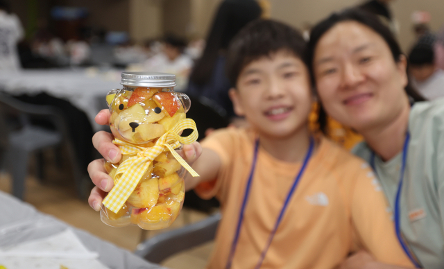 어린이들에게 독서의 재미를 전달하고 체험활동으로 창의력을 길러주기 위한 ‘2025 가족이 함께하는 독서 여름방학 캠프’가 9일 부산 수영구 금련산청소년수련원에서 열렸다. 행사에 참가한 어린이들이 여름과일로 과일청 만들기 체험을 하고 있다. 이재찬 기자 chan@