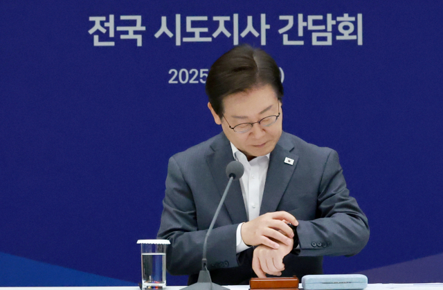 이재명 대통령이 1일 서울 용산 대통령실 청사에서 열린 전국 시도지사 간담회를 시작하며 시간을 확인하고 있다. 연합뉴스