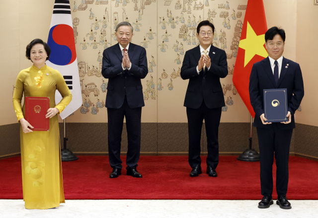 김영훈 고용노동부 장관과 팜 티 타잉 짜 베트남 내무부 장관이 11일 서울 용산 대통령실 청사에서 이재명 대통령과 또 럼 베트남 당 서기장이 임석한 가운데 열린 양해각서(MOU) 서명식에서 인력 송출 및 도입에 관한 MOU에 서명 뒤 기념촬영을 하고 있다. 연합뉴스