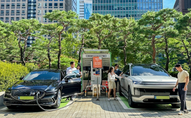 SK이노베이션 계열 직원들이 서울 종로구 SK서린빌딩에서 충전중인 현대자동차 대표 전기차 모델 아이오닉9과 eG80(전기화 모델)을 체험하고 있다. SK이노베이션 제공