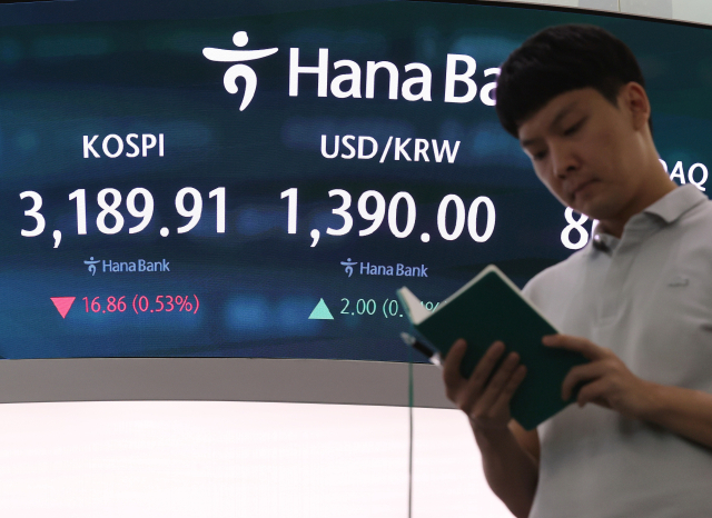 코스피가 12일 국내 세제 개편안과 미국 물가지표 등의 경계감에 하락해 결국 3200선을 내줬다. 12일 서울 중구 하나은행 딜링룸에서 직원이 업무를 보고 있다. 연합뉴스