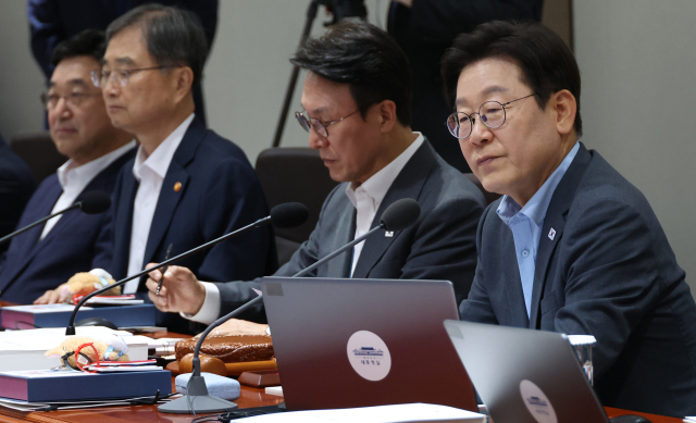 이재명 대통령이 12일 서울 용산 대통령실에서 국무회의를 하고 있다. 이 대통령 자리 앞쪽에 광복 80주년 기념 태극기 달기 캠페인 인형 열쇠고리와 네임택이 놓여 있다. 연합뉴스