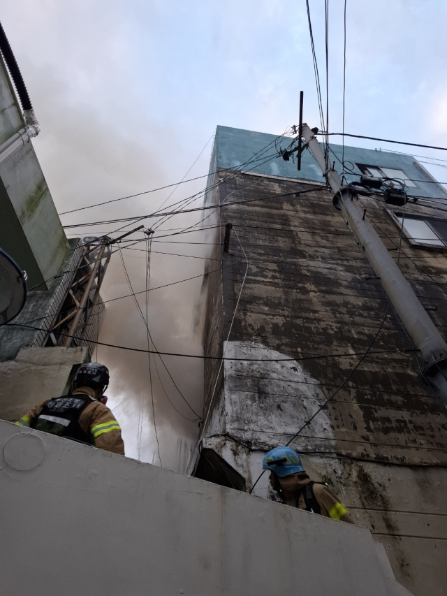 13일 오전 부산 서구 남부민동 한 단독주택에서 불이 나 소방대원들이 진화 작업을 하고 있다. 부산소방재난본부 제공