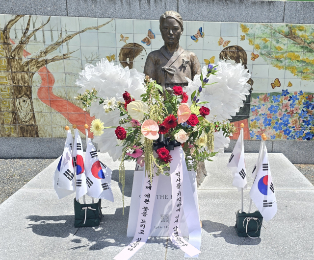학교법인 명덕육영회 산하 함안여자중학교 학생들과 에코플라워협회 함안군 지부 관계자들이 14일 학교 내 소녀상(2019년도 건립)에서 역사 수업과 연계해 광복절 80주년 기념 교육 활동을 펼치고 있다. 함안여자중학교 제공